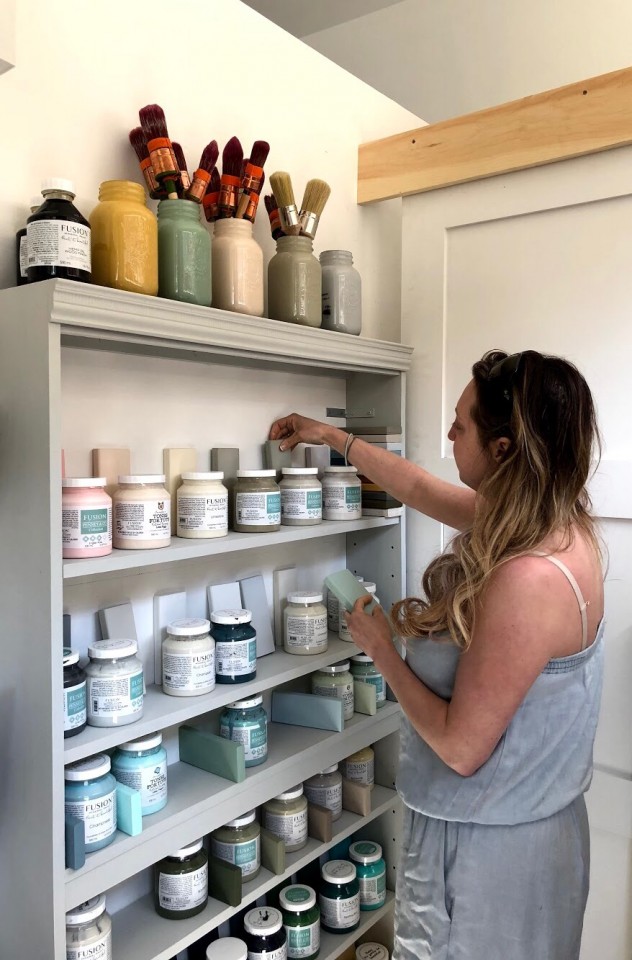 woman organizing paint supplies on shelves