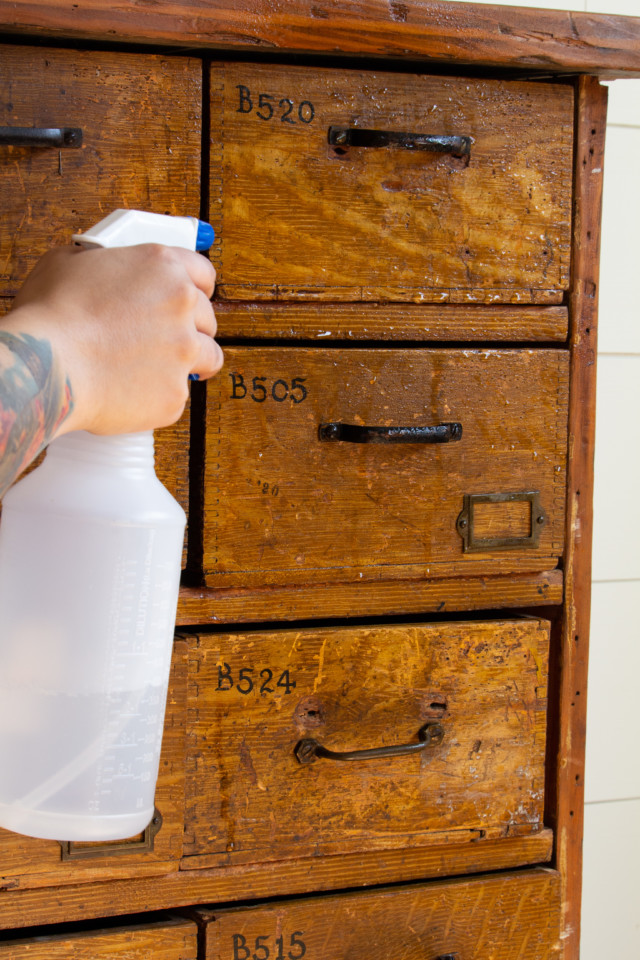 Spraying with TSP to clean the wooden piece of furniture