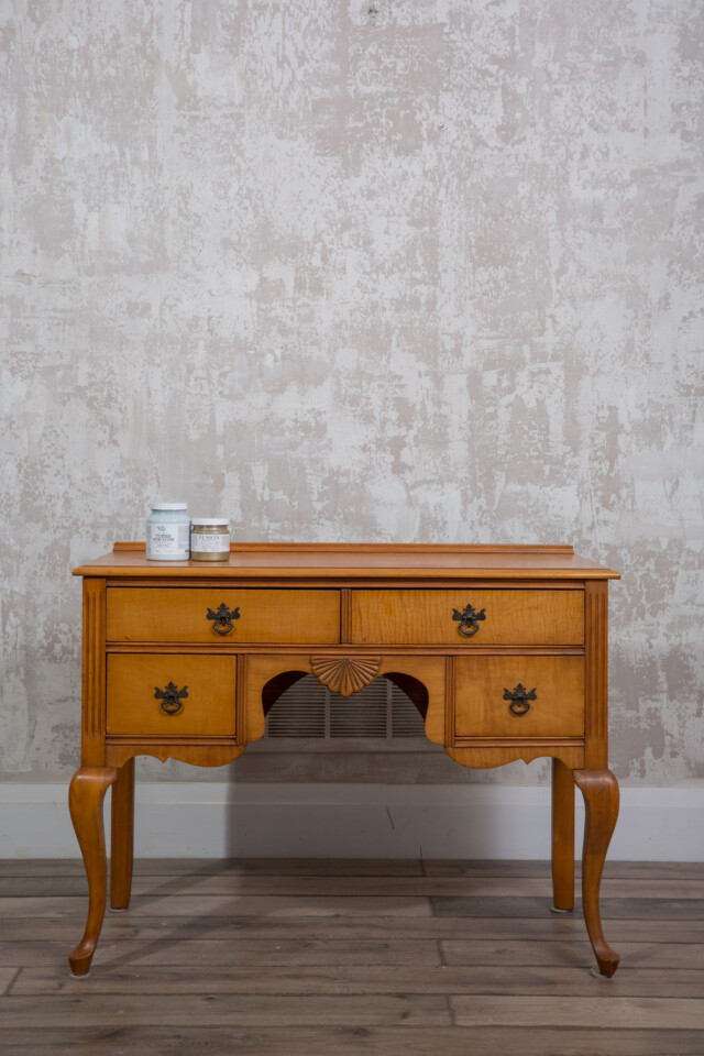 The before dresser, orange toned wood in good condition.