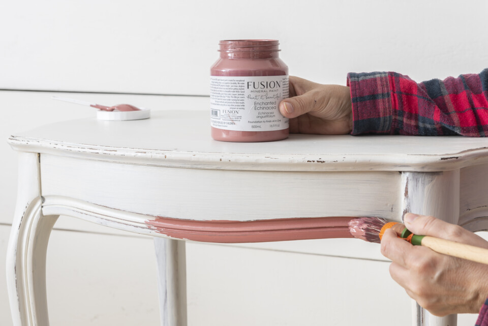 Pot of paint on table with brush 