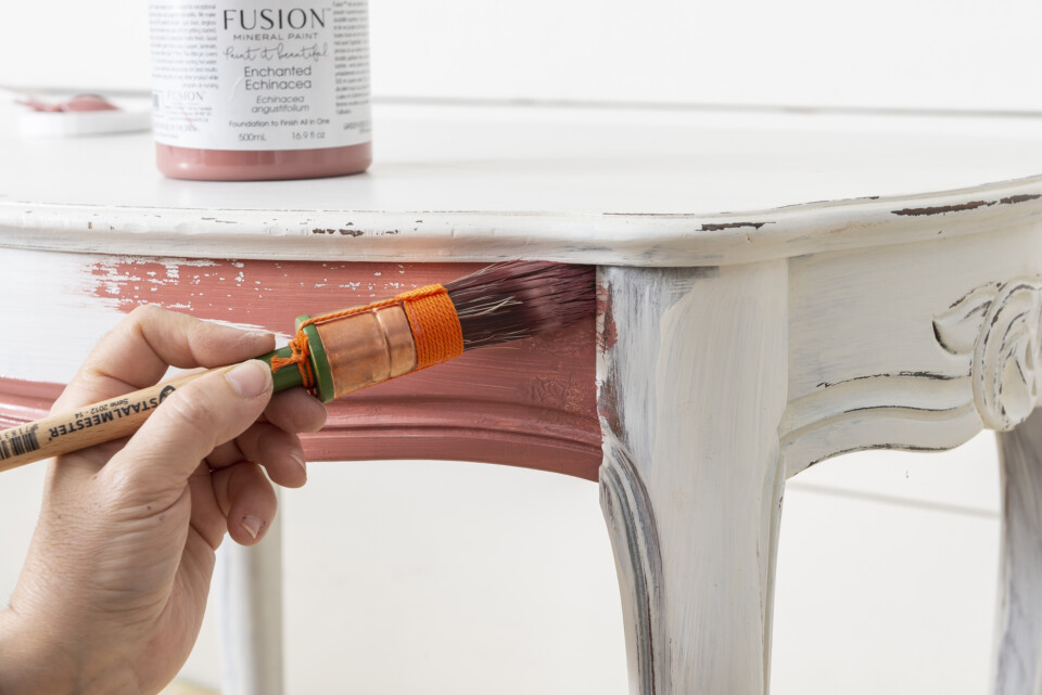 Brush in hand painting a table 