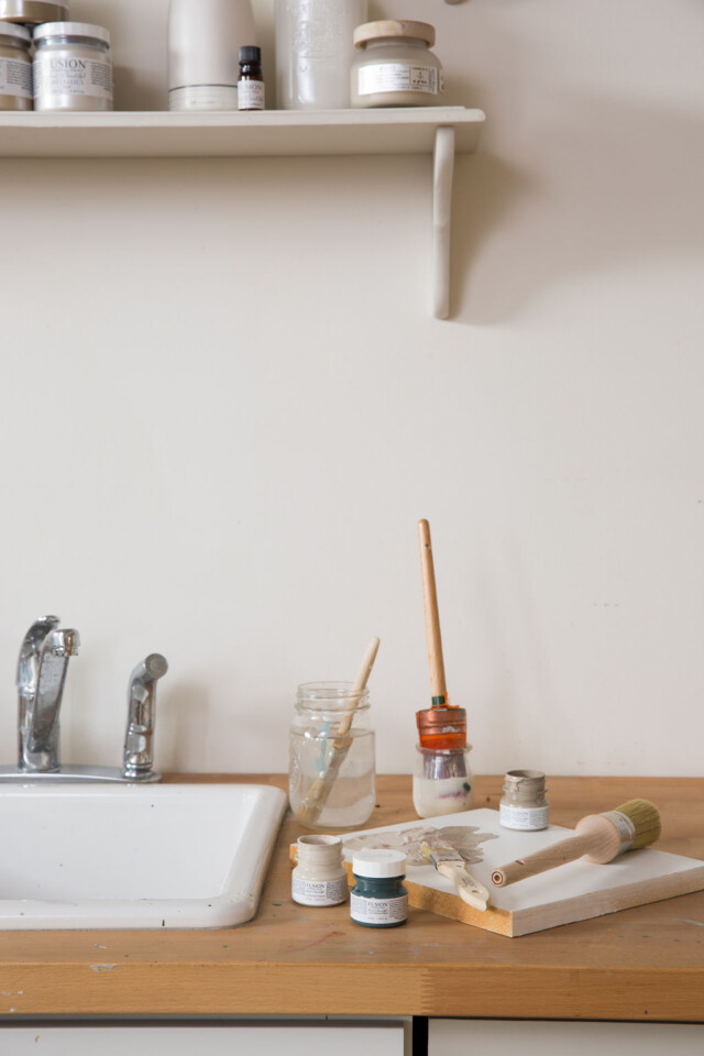 Paint and brushes beside a sink