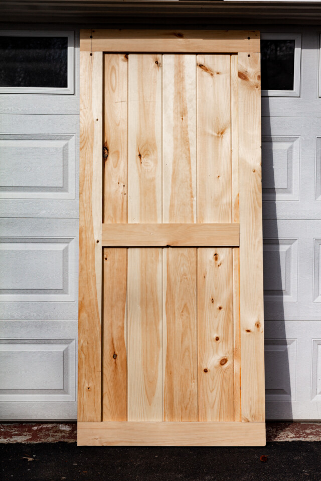 Pine door leaning against garage door