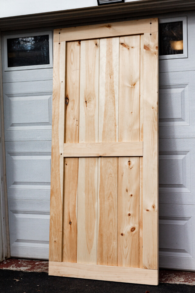 Pine door leaning against garage door