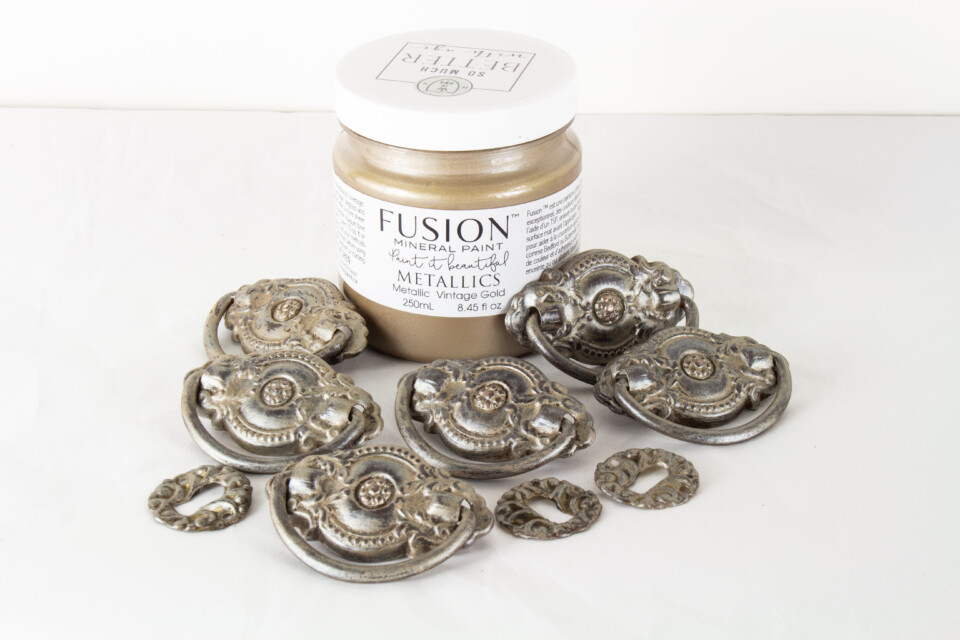 Drawer pulls painted with fusion metallic laying beside jar of metallic