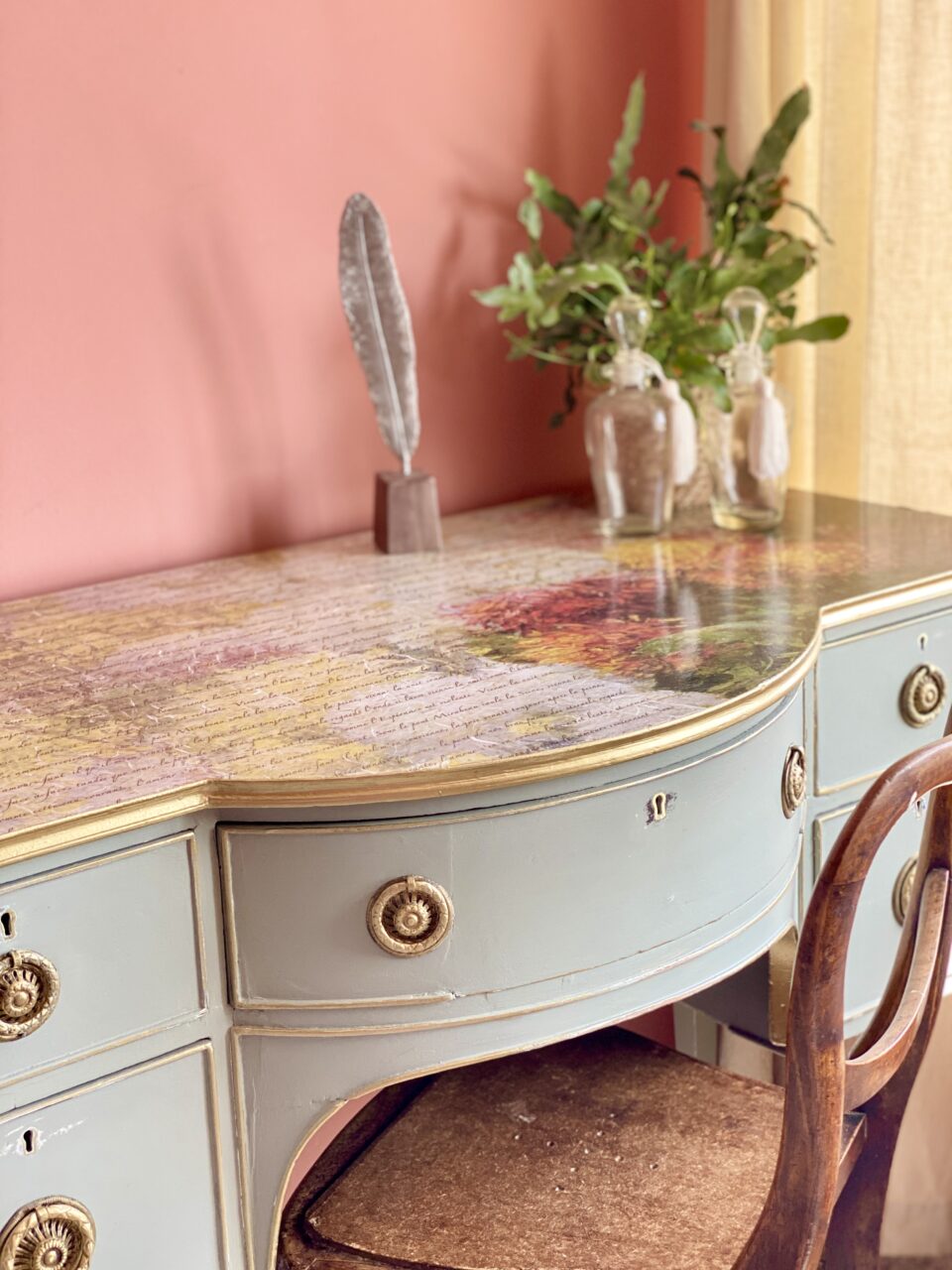 Decoupage dresser staged with two vases filled with flowers placed on top