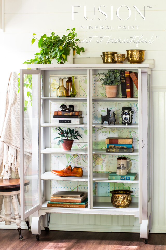 Cabinet with glass doors painted in white, staged with vintage decor