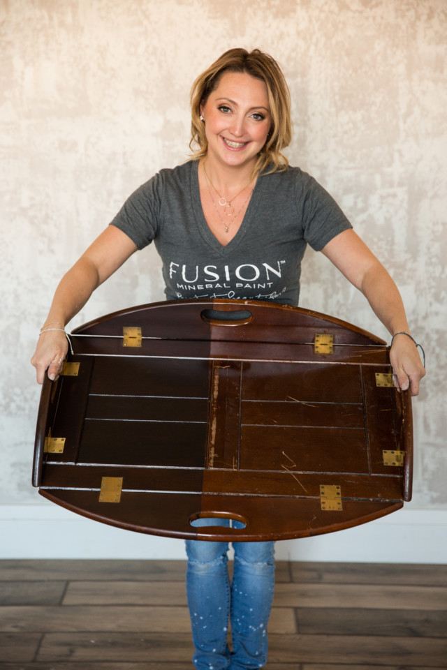 Jennylyn holding up a piece of furniture finished with two different top coats for comparison Fusion Topcoats