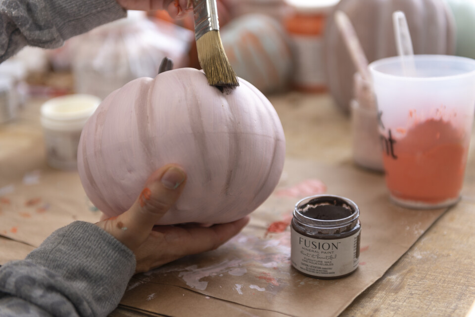 Painting furniture wax onto pink pumpkin