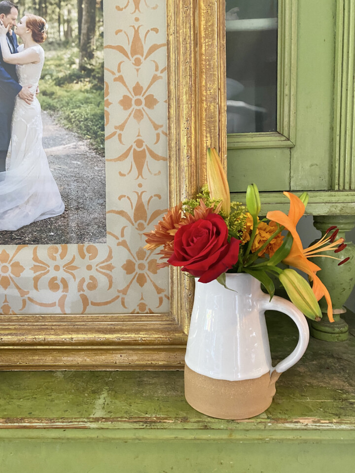 close up image of stencilled part of frame, staged with a vase of flowers