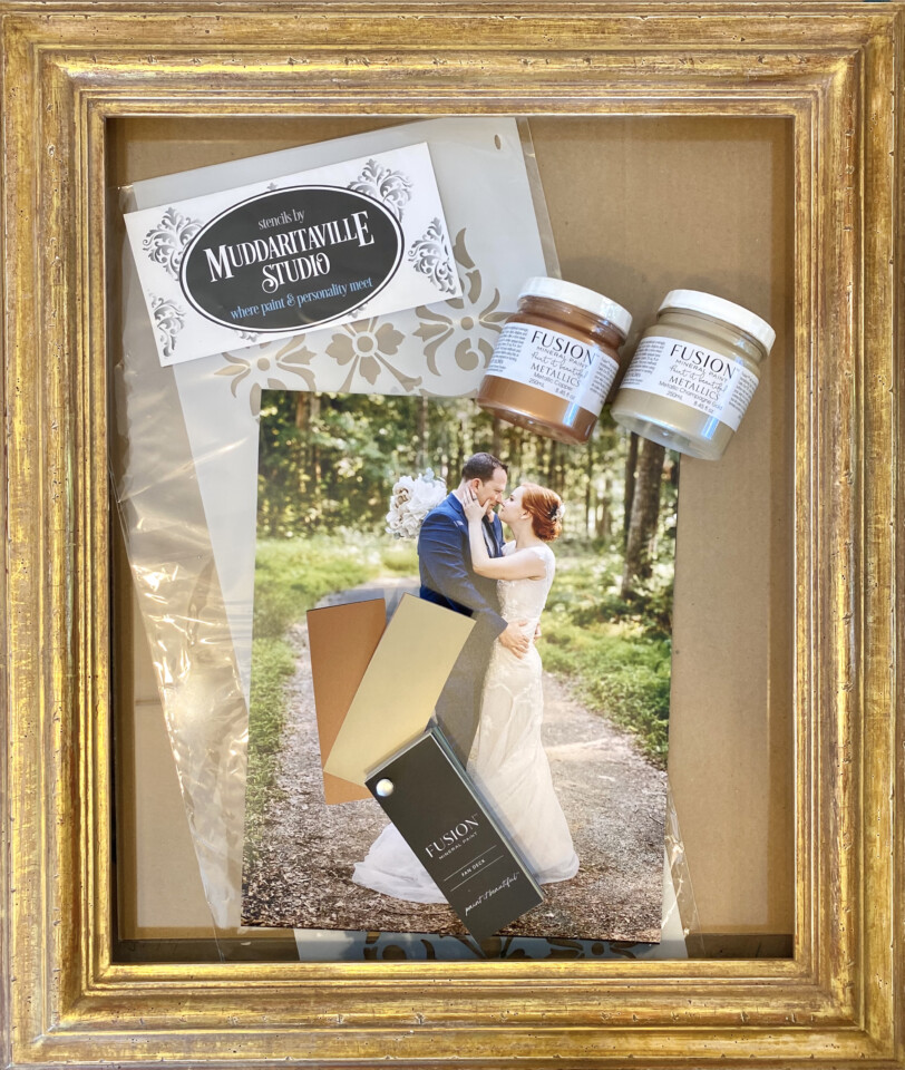 Gold picture frame with a wedding photo, muddaritaville business card, and two testers of FMP metallics
