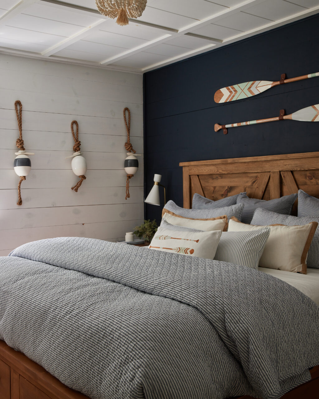 The Nautical Room  / refinished bedroom with dark blue feature wall and hanging canoe paddles painted in fusion milk paint