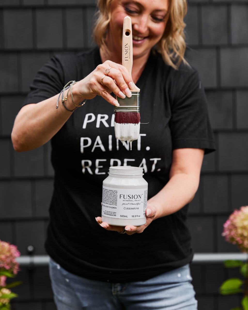 the cottage makeover series / Jennylyn holding pint of cobblestone with paint brush dripping above the pint