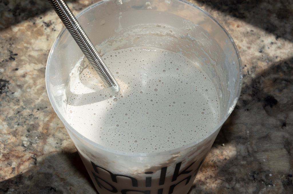 whisking milk paint and water for the Chippy Chic Bar Cabinet Makeover