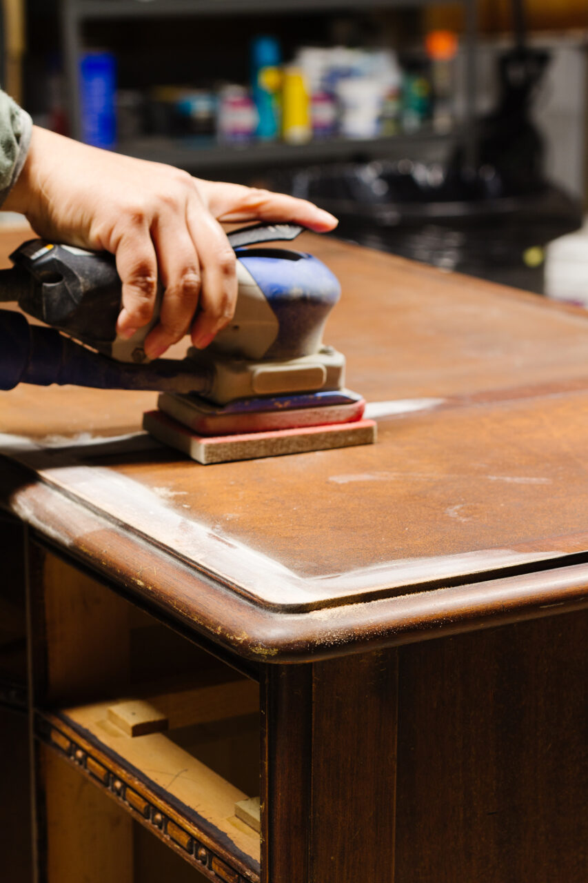 Sanding a wooden desk
